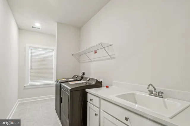 a utility room with a sink dryer and washer