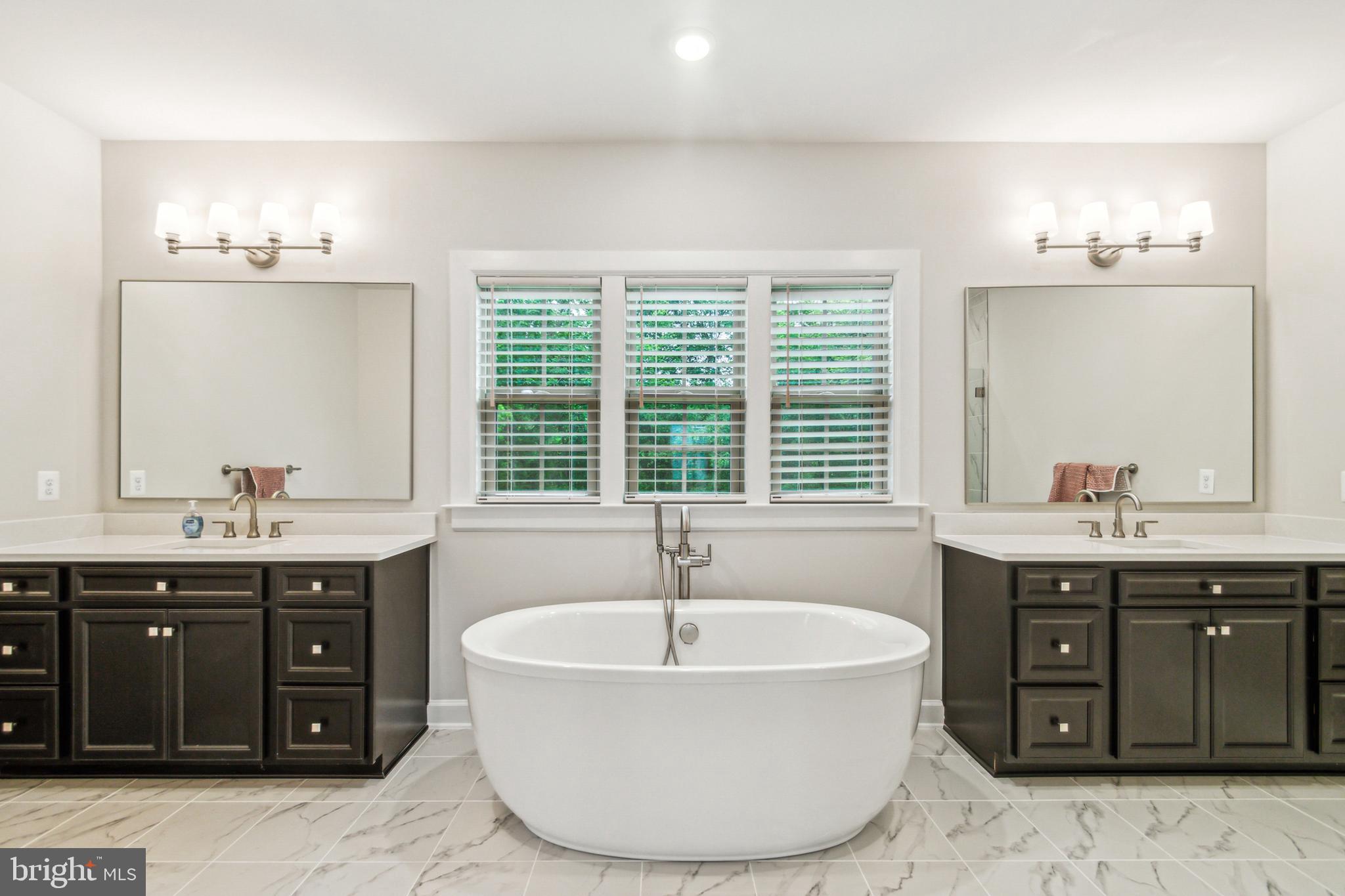 6536 Clubhouse Drive Laurel, MD 20708 - Photo 31 of 40 a spacious bathroom with a tub sink and mirror