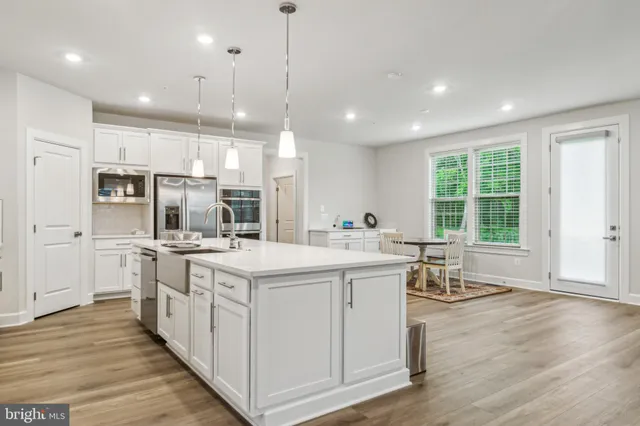 a kitchen with stainless steel appliances kitchen island a large island in the center and wooden floors