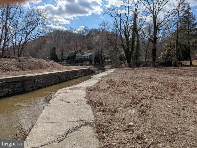a view of a yard with wooden fence