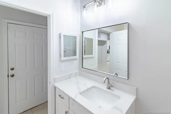 a view of a hallway with wooden floor and a shower