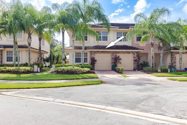 a front view of a house with a garden and trees