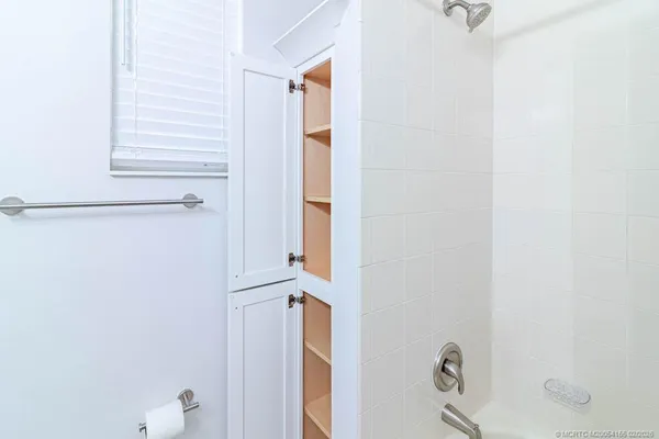 a view of a swimming pool with a lawn chairs under an umbrella