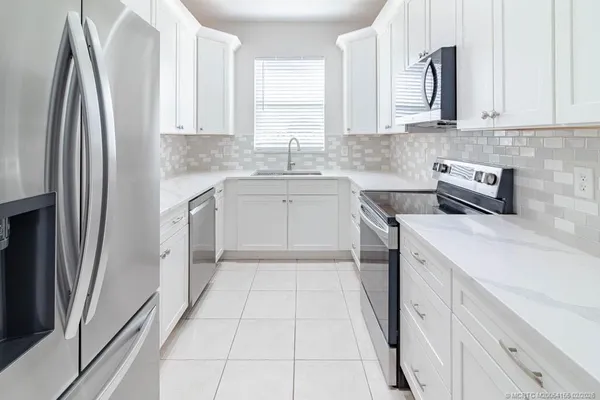 a view of a hallway with wooden floor and a living room