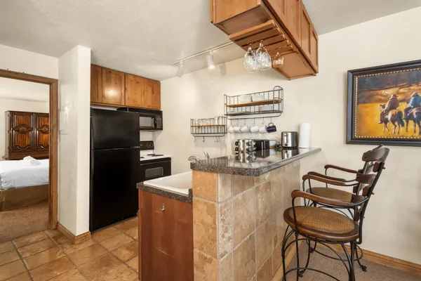 a kitchen with stainless steel appliances granite countertop a refrigerator and a stove top oven