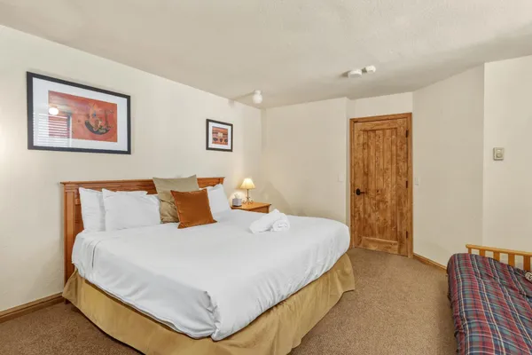 a bedroom with a bed and painting on the wall