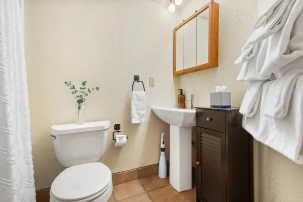 a bathroom with a toilet sink and mirror