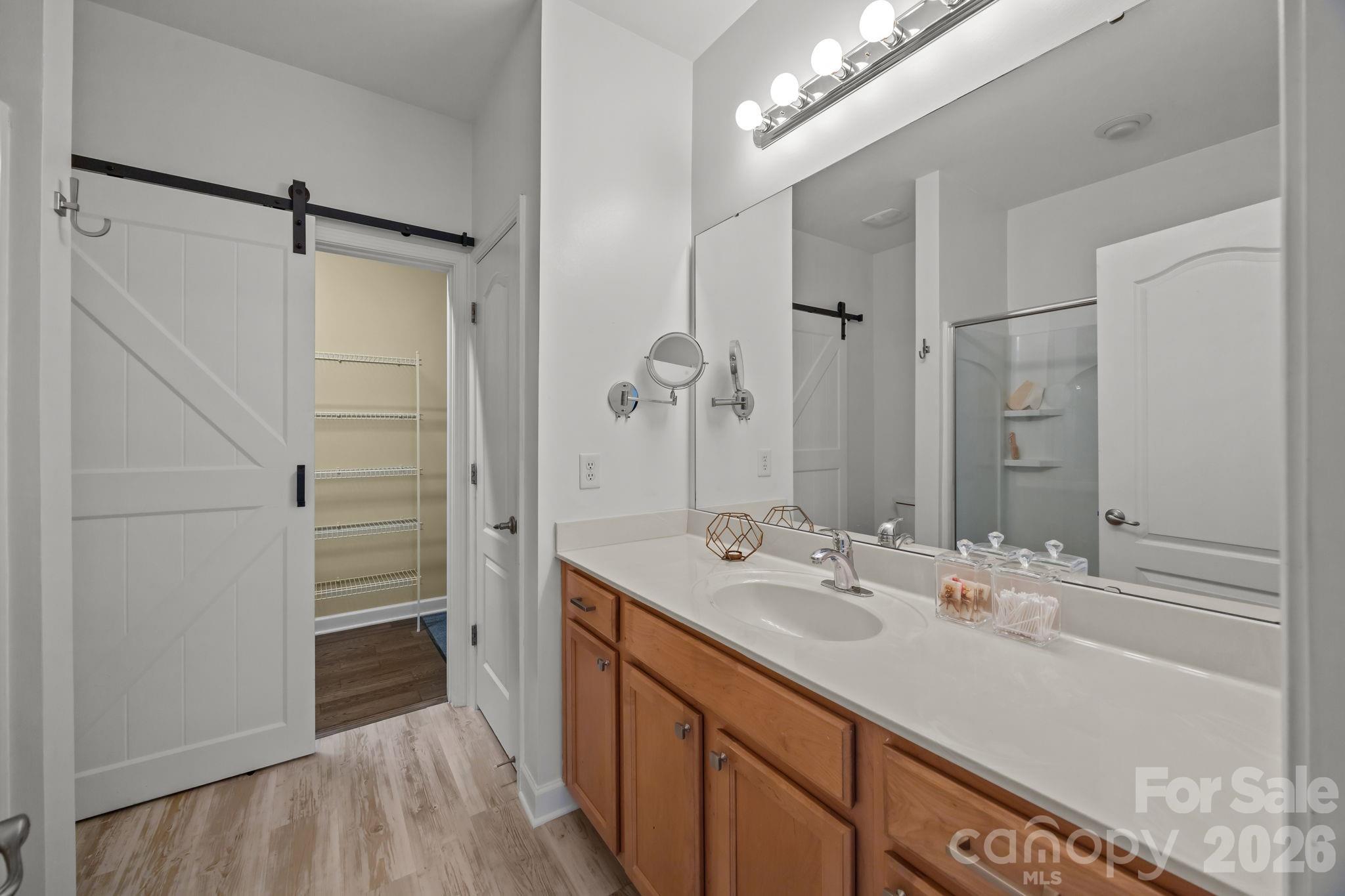 11422 Potters Row Cornelius, NC 28031 - Photo 21 of 46 a bathroom with a double vanity sink a mirror and a shower