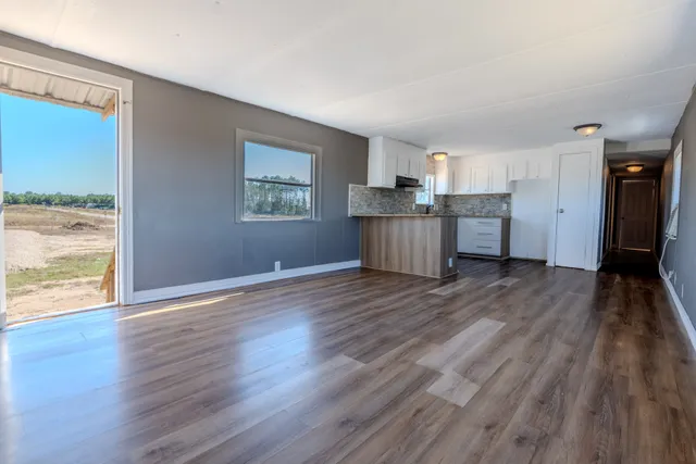 a view of a kitchen with wooden floor and electronic appliances