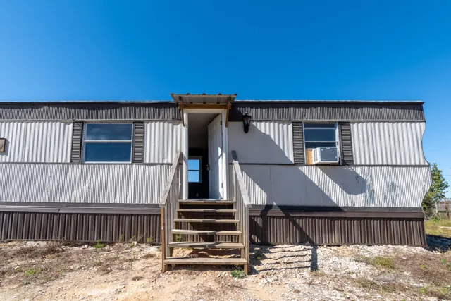 a view of a house with wooden fence