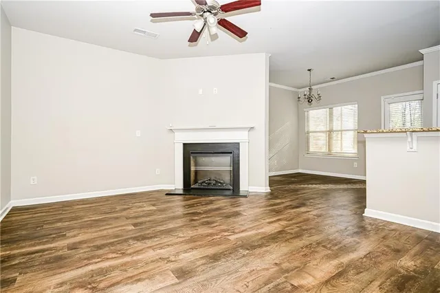 a view of an empty room with window and wooden floor