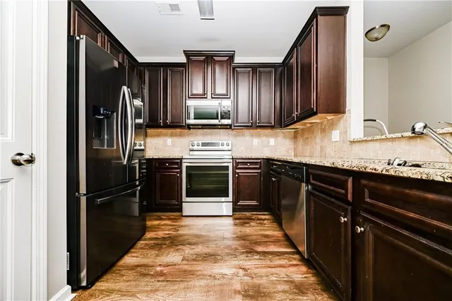 a kitchen with granite countertop stainless steel appliances and wooden cabinets