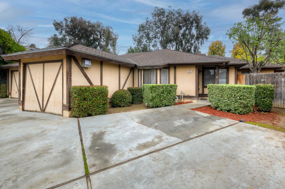 a front view of a house with a yard and potted plants