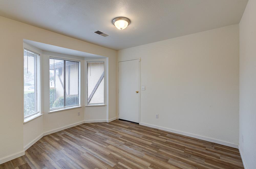 7580 North Angus Street, Unit 103 Fresno, CA 93720 - Photo 15 of 33 a view of an empty room with wooden floor and a window