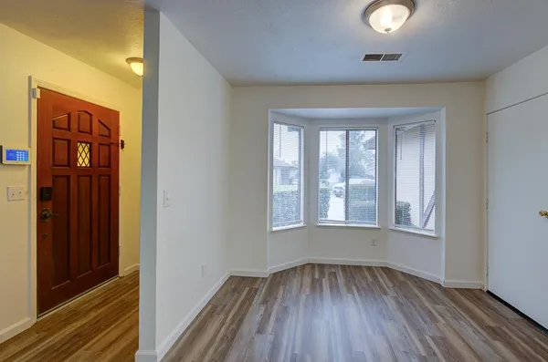 a view of empty room with wooden floor