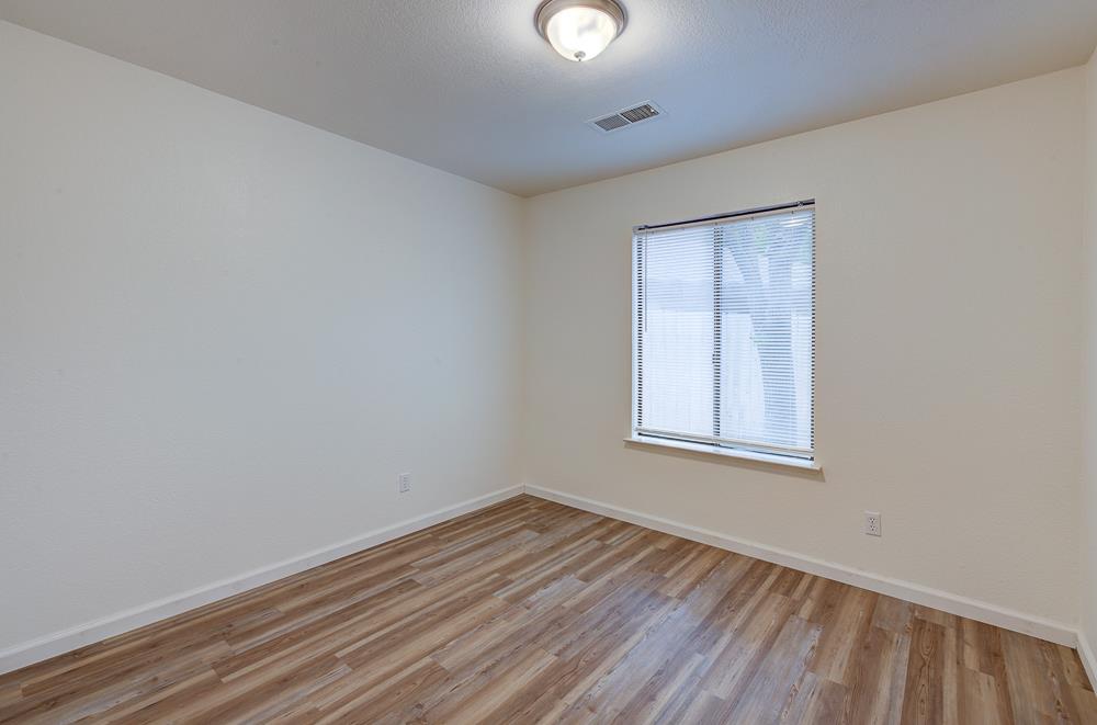 7580 North Angus Street, Unit 103 Fresno, CA 93720 - Photo 23 of 33 an empty room with wooden floor and windows