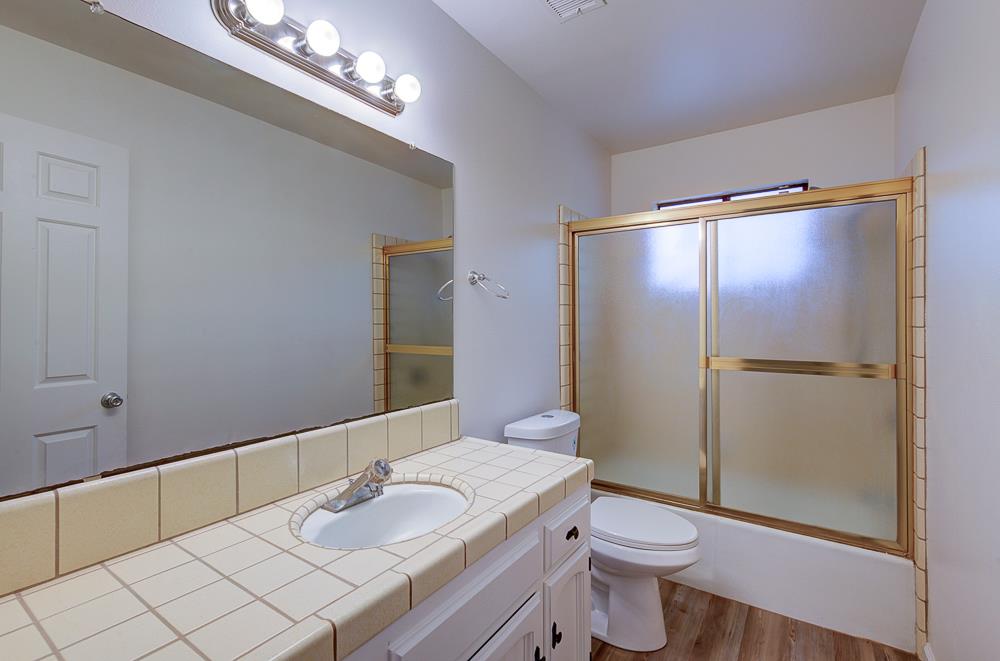 7580 North Angus Street, Unit 103 Fresno, CA 93720 - Photo 25 of 33 a bathroom with a granite countertop sink and a mirror