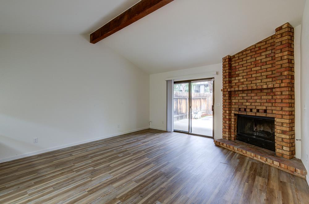 7580 North Angus Street, Unit 103 Fresno, CA 93720 - Photo 9 of 33 a view of an empty room with wooden floor fireplace and a window