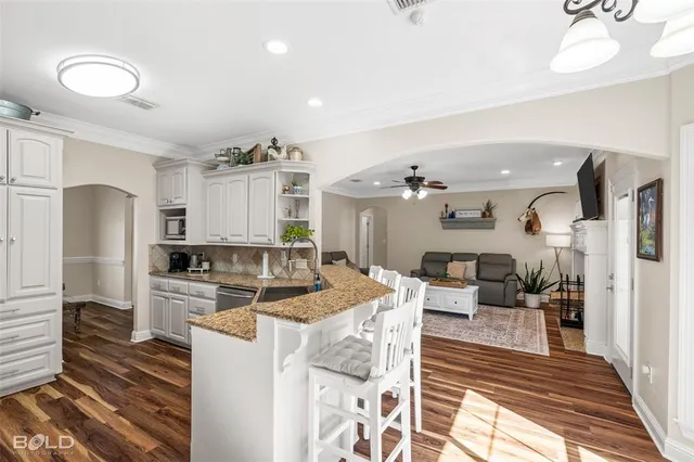 a kitchen with stainless steel appliances kitchen island granite countertop a refrigerator a stove a kitchen island with a dining table and chairs