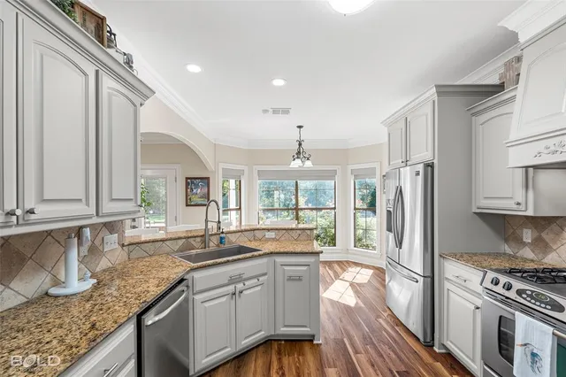 a kitchen with stainless steel appliances kitchen island granite countertop a refrigerator and microwave
