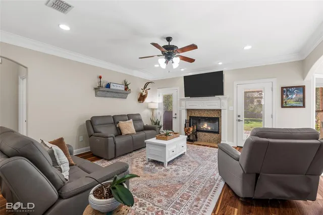 a living room with furniture a fireplace and a flat screen tv