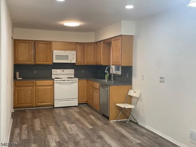 a view of kitchen with sink microwave and cabinets