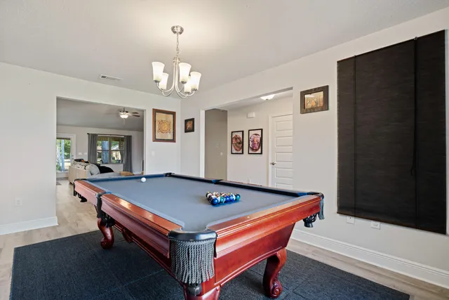 a room with pool table and windows