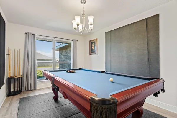 a room with pool table and windows