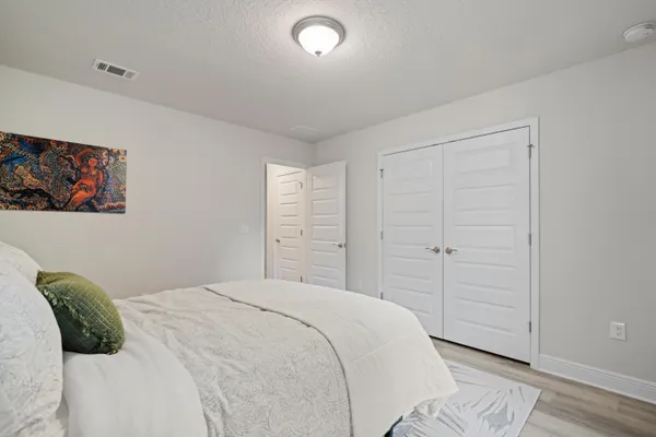 a bedroom with a bed and a painting on the wall