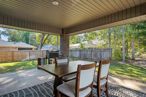 a view of a patio with table and chairs next to a yard