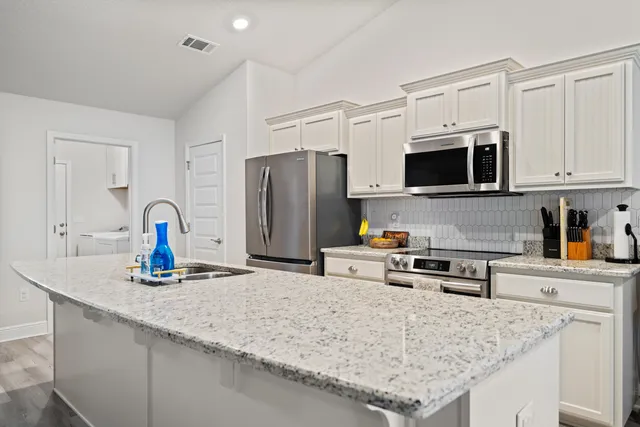 a kitchen with stainless steel appliances granite countertop a sink refrigerator and microwave