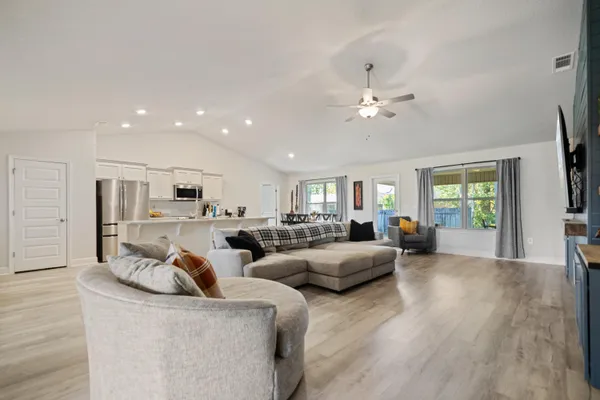 a living room with furniture a ceiling fan and a window