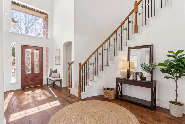 a living room with wooden floor and a potted plant