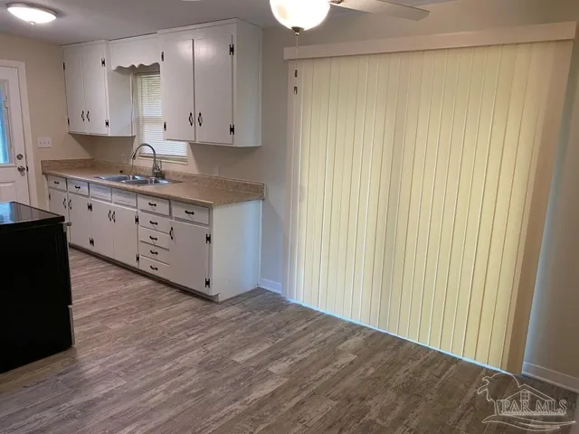 a kitchen with granite countertop white cabinets and stainless steel appliances