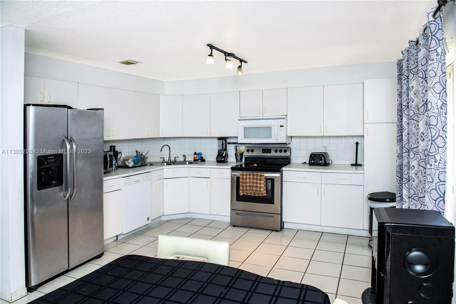 11331 Rockinghorse Road Cooper City, FL 33026 - Photo 7 of 10 a kitchen with a sink a stove and refrigerator