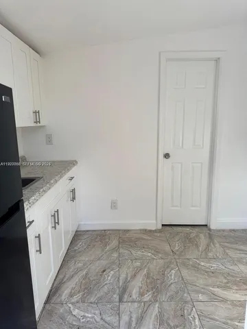 a view of a kitchen with granite countertop cabinets