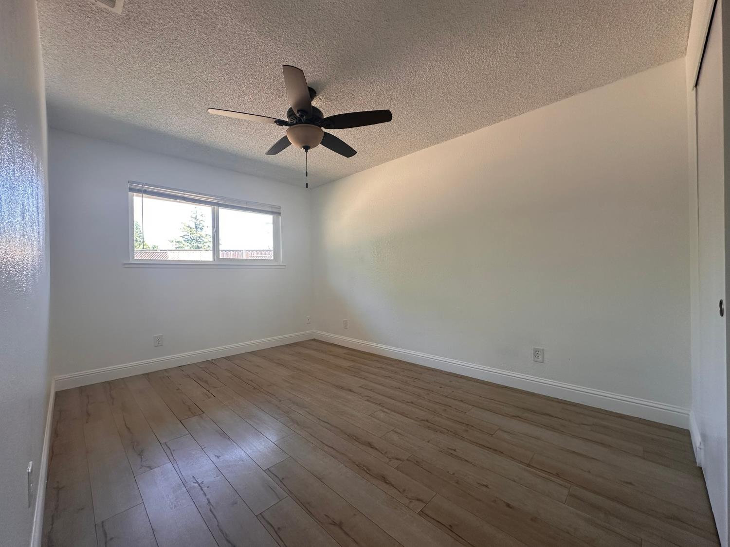 5743 Haskell Avenue Carmichael, CA 95608 - Photo 13 of 47 an empty room with wooden floor fan and windows