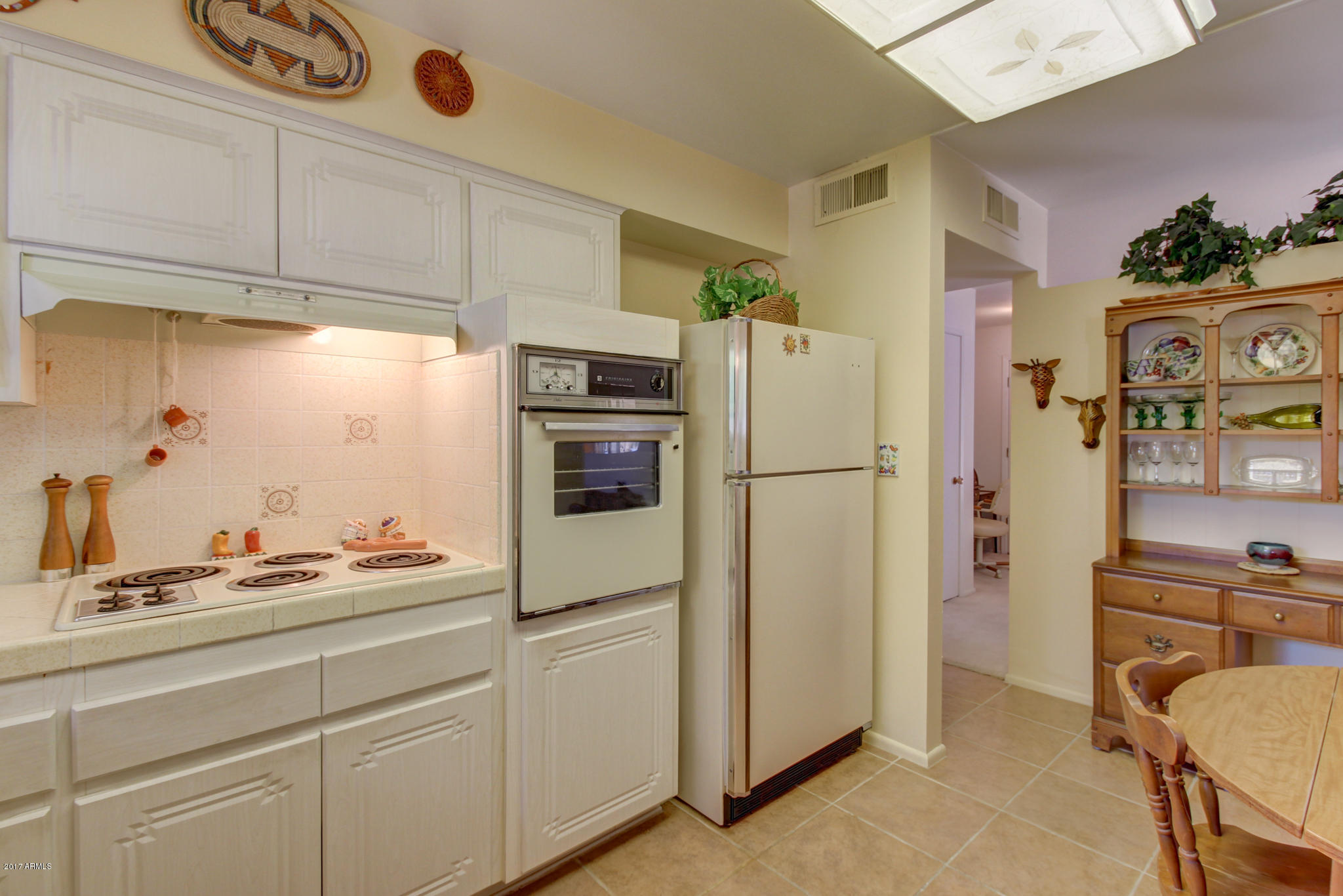 10008 West Riviera Drive Sun City, AZ 85351 - Photo 13 of 26 a kitchen with refrigerator a cabinets and wooden floor