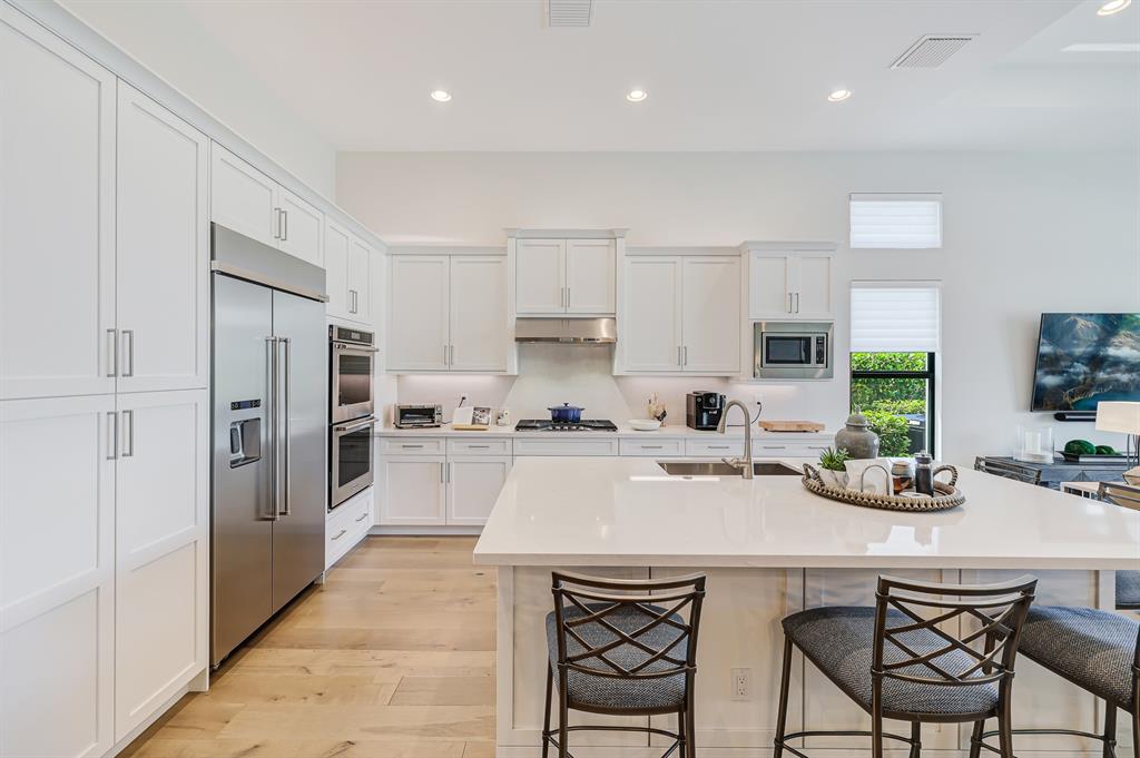 17401 Santaluce Manor Boca Raton, FL 33496 - Photo 15 of 84 a kitchen with white cabinets and stainless steel appliances