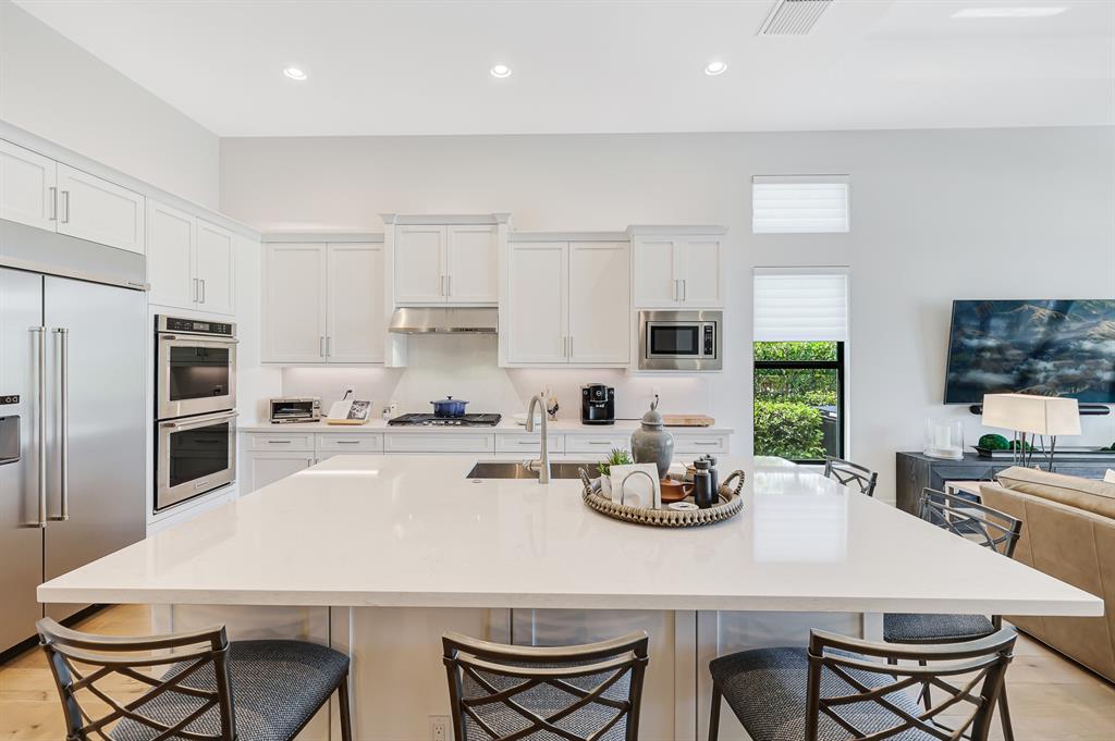 17401 Santaluce Manor Boca Raton, FL 33496 - Photo 17 of 84 a kitchen with stainless steel appliances a table and chairs in it