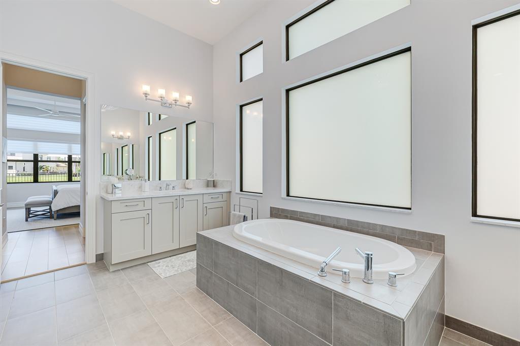17401 Santaluce Manor Boca Raton, FL 33496 - Photo 28 of 84 a bathroom with a tub a sink and a mirror