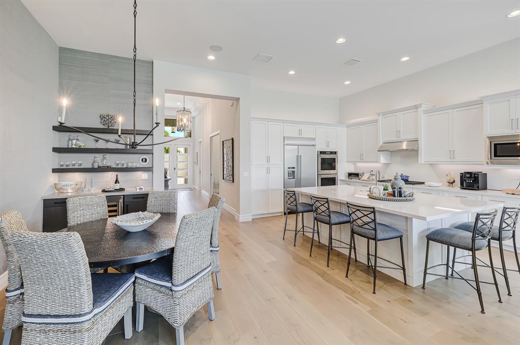 17401 Santaluce Manor Boca Raton, FL 33496 - Photo 10 of 84 a kitchen with stainless steel appliances kitchen island granite countertop a dining table chairs and a refrigerator