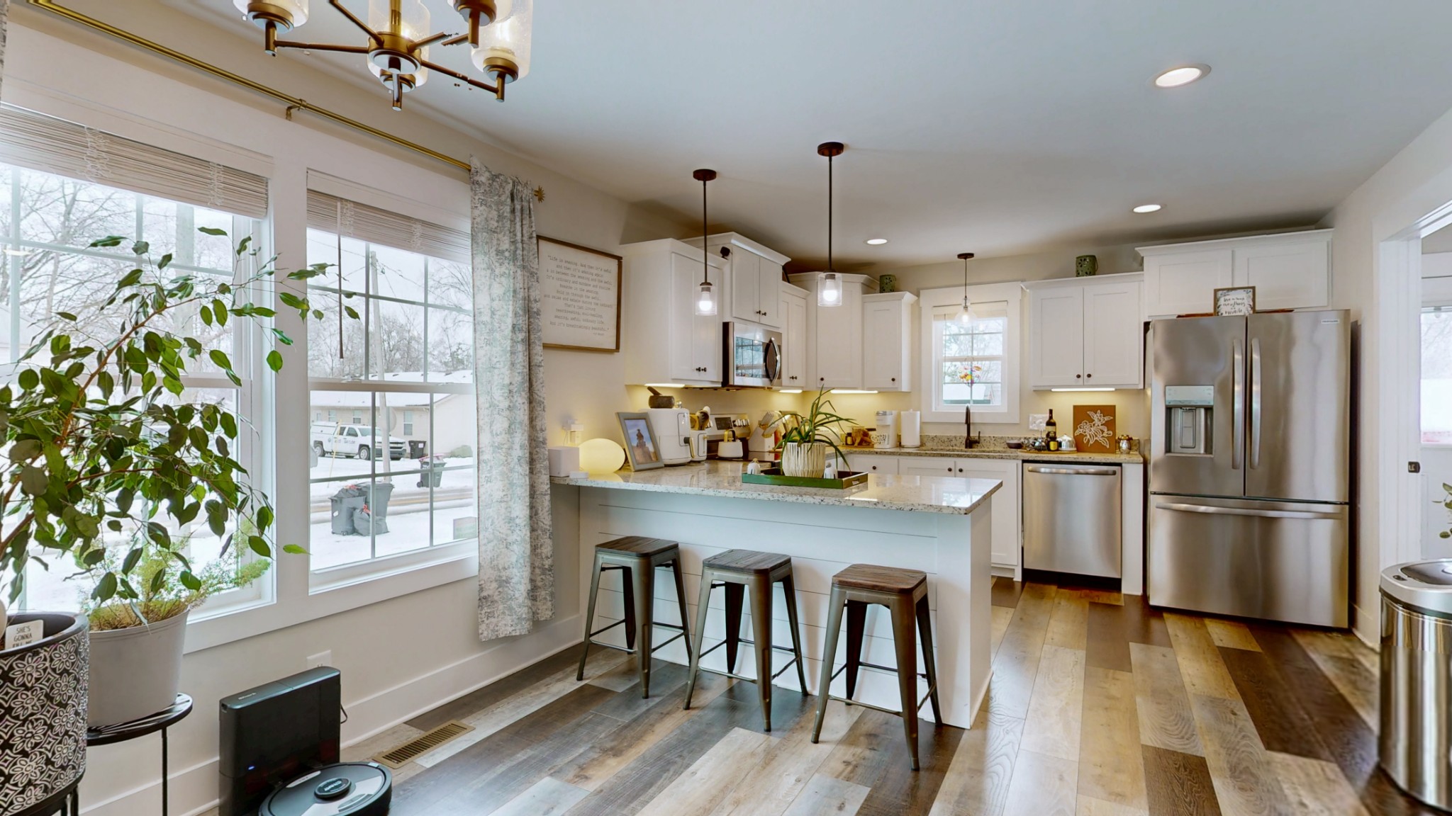 a kitchen with refrigerator a stove and a wooden floor