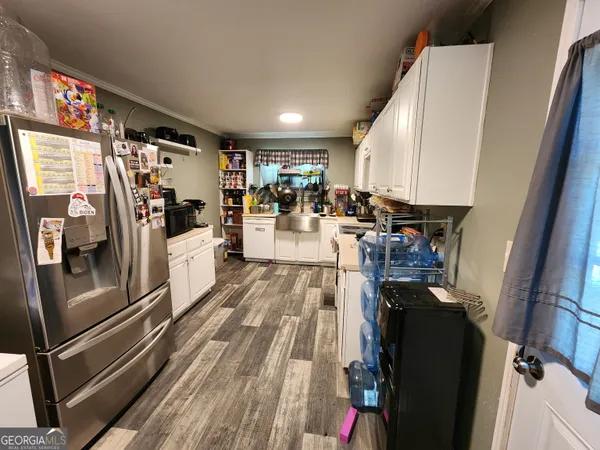 a view of a living room with stainless steel appliances furniture a refrigerator and kitchen view