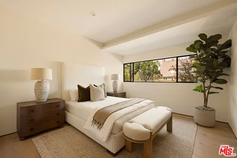 a bedroom with a bed and a potted plant