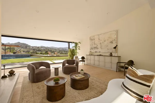 a living room with furniture and a floor to ceiling window