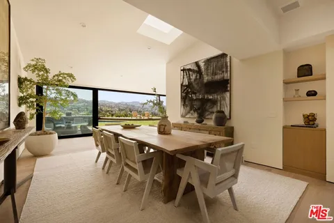 a dining room with furniture and a floor to ceiling window