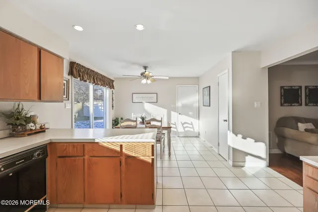 a large white kitchen with a stove a sink dishwasher and a refrigerator with wooden floor