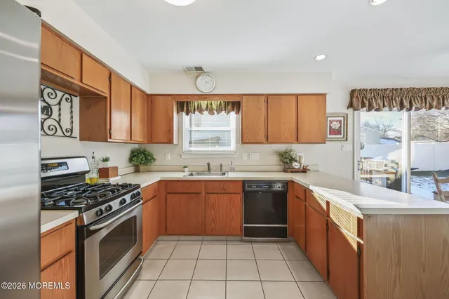 a kitchen with stainless steel appliances granite countertop a stove sink and cabinets