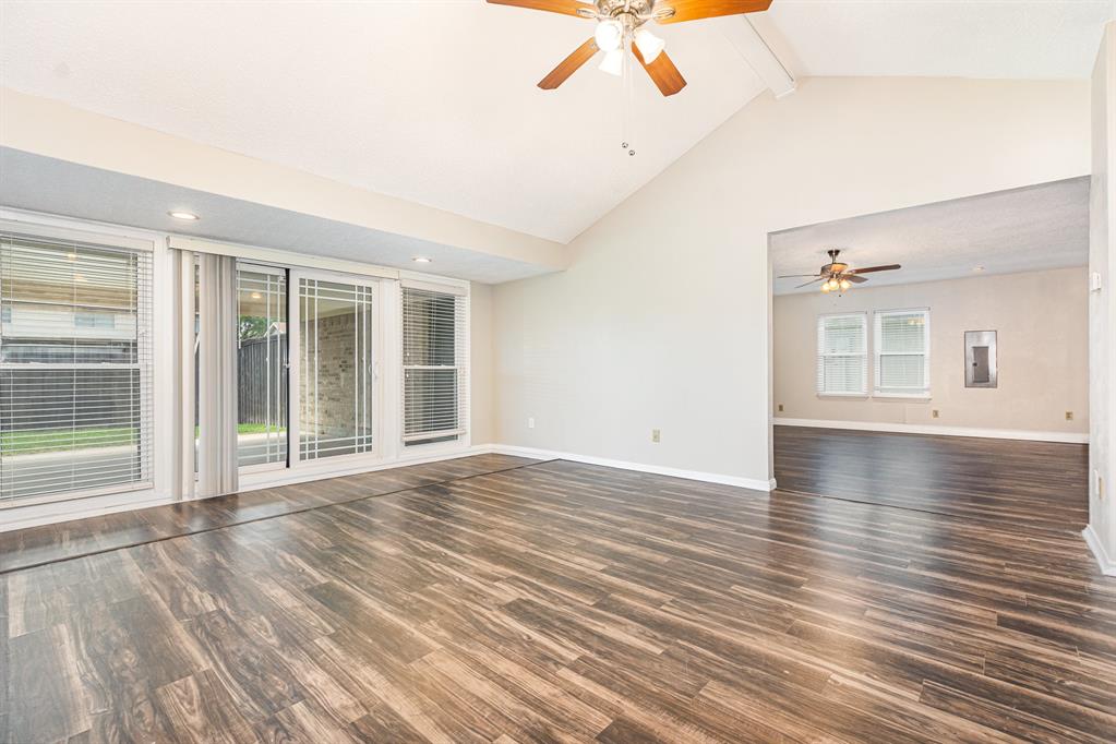 229 South Heartz Road Coppell, TX 75019 - Photo 6 of 18 Empty room featuring ceiling fan, wood finished floors, beamed ceiling, and high vaulted ceiling